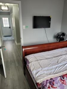 布兰普顿Individual home的卧室配有一张壁挂式平面电视的床。