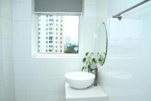 大叻TTG Hostel DaLat的白色的浴室设有水槽和窗户。
