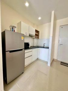 功孟海滩Chez Wanida - apartment Krabi的厨房配有不锈钢冰箱和白色橱柜