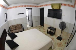 布加La Hermosa Hotel的一间卧室配有一张床和一台平面电视