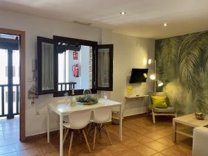 格拉纳达Apartamentos Inside Casa de la Alberca的一间配备有白色桌椅的用餐室