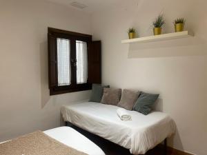格拉纳达Apartamentos Inside Casa de la Alberca的小房间设有床和窗户