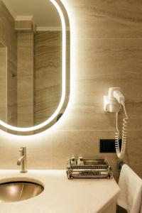 基希讷乌周末精品酒店 的一间带镜子和电话的盥洗盆的浴室