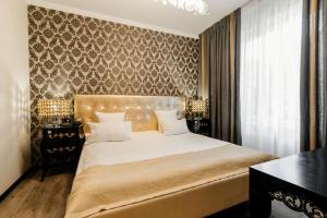基希讷乌周末精品酒店 的卧室配有一张白色大床和一堵墙
