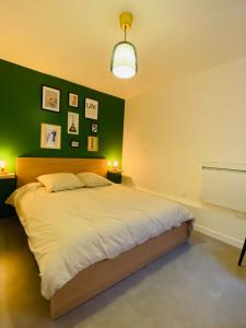 TilléTHE SHARE HOUSE的一间卧室设有一张大床和绿色的墙壁