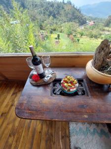 圣弗朗西斯科Refugio Naturaleza en Armonia的一张桌子,上面放着一瓶葡萄酒和一盘食物