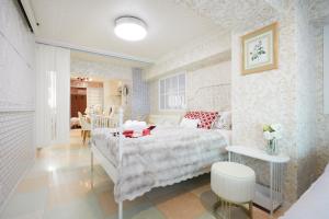 东京Papillon Paradis Higashi-Shinjuku的卧室配有白色的床和桌子