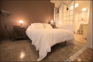 托洛萨Tolosa un mundo de sensaciones的一间卧室配有一张带白色床单和一盏灯的床。