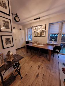 华沙Apartament Czerwone Maki的一间带桌椅和时钟的用餐室