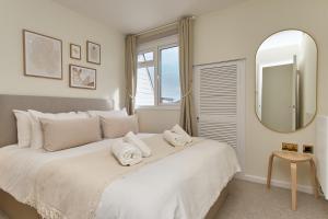考斯West Cowes Penthouse的卧室配有一张带镜子的白色大床