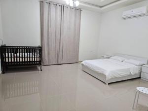 马斯喀特La Villa Muscat的白色卧室配有床和椅子