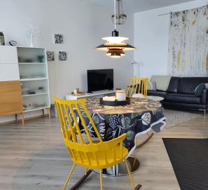 罗瓦涅米Arctic Apartment with own Sauna的客厅配有桌子和黄色椅子
