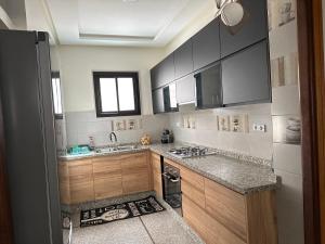 拉巴特Appartement la gare Rabat ville的厨房配有木制橱柜、水槽和窗户。