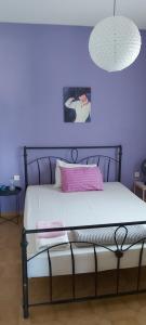穆尔特里Giannis Stella apartment的一间卧室配有一张紫色墙壁的床