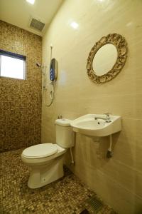 怡保景园公寓的一间带卫生间、水槽和镜子的浴室