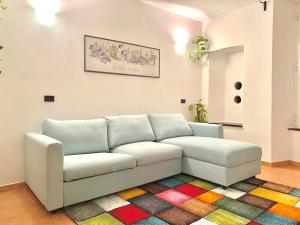 韦尔纳扎La Marina Vernazza Appartamento Piazza Marconi的一张白色沙发,房间铺着色彩缤纷的地毯