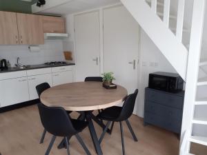 曲马勒姆4-persoons vakantiehuisje Simmerwille的一间厨房,内设一张木桌和椅子