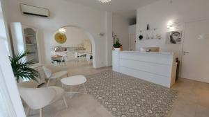 佩斯基奇La Locanda della Castellana adults only的厨房以及带白色椅子和桌子的用餐室