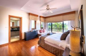 邦涛海滩Laguna Pool Villa - Tranquil Views的一间卧室配有一张床、一张沙发和一个窗口