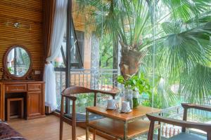 宁平Tam Coc Serenity Hotel & Bungalow的一间设有桌子和棕榈树的用餐室