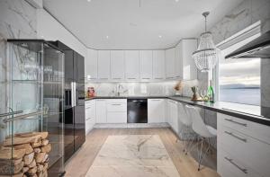 哈尔斯塔AA Home Solgryveien Harstad的厨房配有白色橱柜和黑色冰箱。