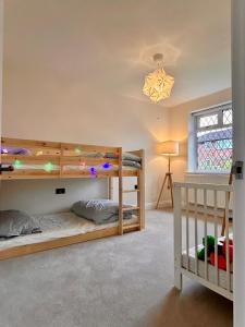 TimperleyNature Inspired Bungalow with 3 rooms - 10 mins from Manchester Airport的一间卧室设有两张双层床和一扇窗户。