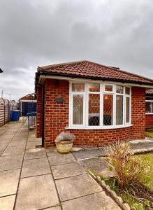 TimperleyNature Inspired Bungalow with 3 rooms - 10 mins from Manchester Airport的一个小红砖房子,有窗户