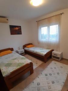 蒂瓦特Apartment Potpara的一间卧室设有两张床和窗户。