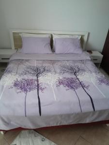 蒂瓦特Apartment Potpara的一张带紫色和白色床单的床,上面有树木
