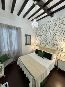 加的斯Palacete de La Alameda - Adults Only-的卧室配有一张白色大床和一堵墙