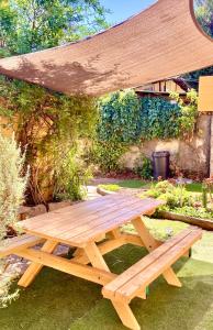 圣地亚哥Urban Lodge Providencia的花园中设有木餐桌和天篷