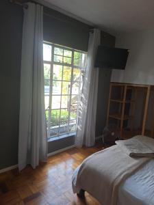 逊邱伦Die Eend Studio的一间卧室设有一张床和一个大窗户