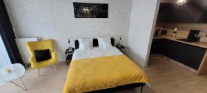 什切青Hanza Tower Apartament 306, BASEN, SAUNA, JACUZZI的一间卧室配有黄色的床和黄色的椅子