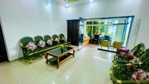 蒙纳The RaaRees Resort - A Hidden Resort in Munnar的客厅配有绿色沙发和桌子