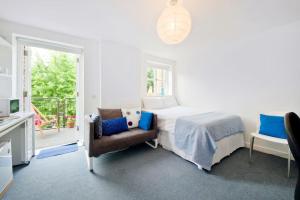 伦敦Zone 1! 2 bed duplex Apartment!的白色卧室配有床和椅子