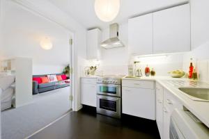伦敦Zone 1! 2 bed duplex Apartment!的白色的厨房配有白色橱柜和客厅。