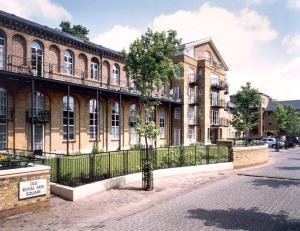 伦敦Zone 1! 2 bed duplex Apartment!的前面有栅栏和树的建筑