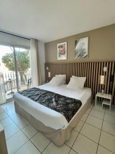 滨海阿热莱斯Acapella Hotel的一间带大床的卧室和一个阳台