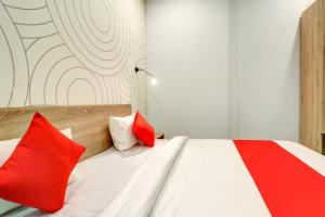 新德里OYO Flagship JPS Grand Hotel的一间卧室配有红色和白色枕头的床