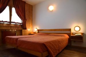 圣卡特琳娜瓦尔夫Hostel San Matteo的卧室配有一张床,墙上有两盏灯