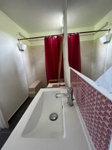 三河市Eden Créole的浴室设有水槽和红色的淋浴帘