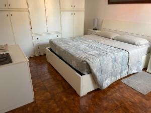 雷诺河畔卡萨莱基奥Bilocale Incantevole的一间卧室配有一张带白色橱柜的大床