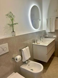 孔韦尔萨诺Alchimia Apartment的一间带水槽、卫生间和镜子的浴室