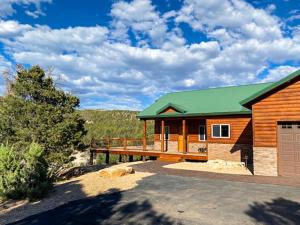 奥德维尔Escape to Tranquility: Amazing Cabin Near Zion的一座带绿色屋顶和车库的木屋