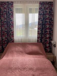 VrhpoljeApartmani Urošević的卧室配有粉红色的床和窗户