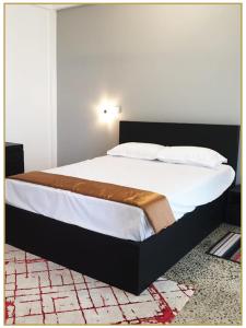 SerukeleOrange Guest Homes & Banquet Hall的卧室配有一张带白色床单和枕头的大床。
