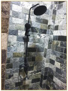 SerukeleOrange Guest Homes & Banquet Hall的带淋浴的浴室(铺有瓷砖地板)