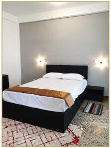 SerukeleOrange Guest Homes & Banquet Hall的一间卧室配有一张带白色床单的大床