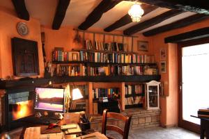 乌尔比诺伊尔毕若裘乡村民宿的一间设有一张桌子、一台电脑和书架的房间