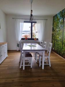 鲁多尔施塔特Ferienwohnung Cumbach的白色的餐桌、白色的椅子和窗户